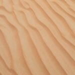 A serene view of golden sand dunes with smooth textures in Dubai's desert, perfect for backgrounds and wallpapers.